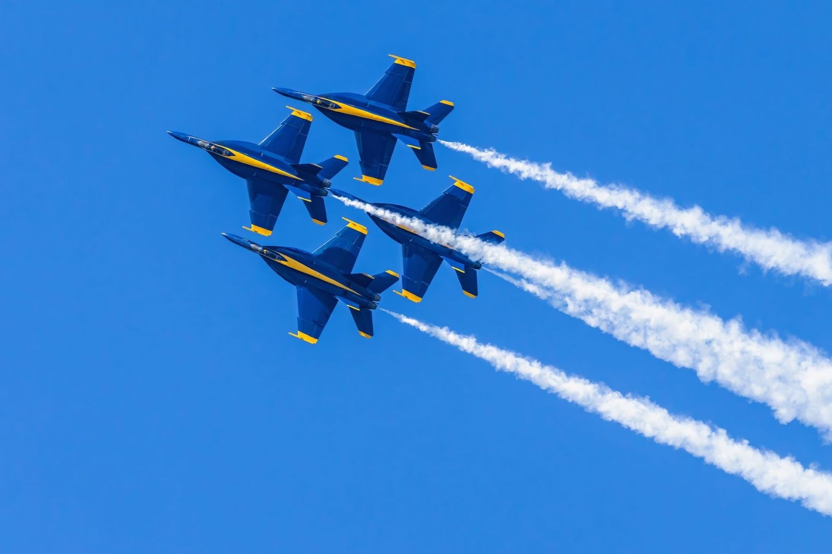 Quatre avions de voltige bleus et jaunes en formation dans le ciel